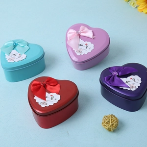 Detailed view of heart-shaped metal gift boxes with silk bows and elegant engravings