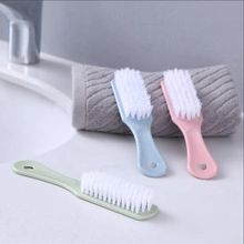 Close-up of portable sponge cleaning brush with long handle and soft white bristles