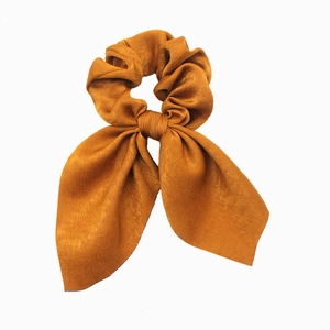 Ginger yellow satin bow hair scrunchie with long ribbon on a white background