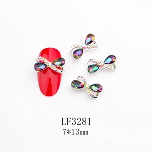 Dettaglio decorazione unghie a fiocco in metallo 7x13mm con strass su unghie rosse