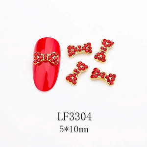 Dettaglio macro dei ciondoli per unghie a fiocco rosso 5x10mm con base in metallo dorato