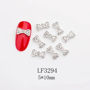 Dettaglio di decorazioni per unghie a forma di fiocco argento con strass lucidi