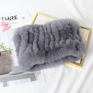 Flat lay of gray faux rabbit fur neck warmer on white fabric with fashion magazine