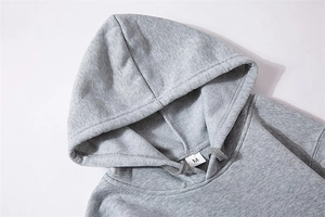 Detail shot of grey hoodie neckline showing M size label and cotton fabric texture