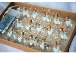 Detail of LED Christmas string lights with reindeer pattern glass jars in a kraft gift box