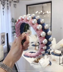 Detail of pink and blue velvet headband with large faux pearls and textured wrap