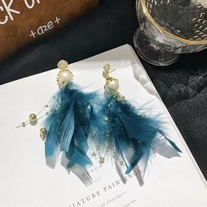 Close-up of vintage feather tassel earrings with dark green feathers and faux pearls