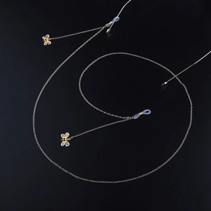 Silberne Brillenlkette aus Metall mit Bienenanhängern und Silikonenden auf schwarzem Grund