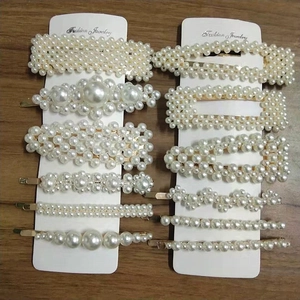 Detailed set of 12 handmade pearl hair clips with gold metal bases on a display card
