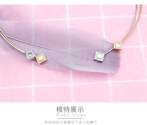 Detail of square crystal pendant on gold and silver stainless steel choker necklace