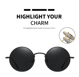 Detail view of round vintage sunglasses featuring black matte frames and gold metal hinges