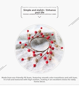 Detailed view of artificial red berry wreath with golden textured balls on soft white background