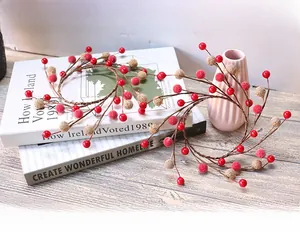 Close-up of a festive Christmas berry wreath with red and beige beads for candle decor