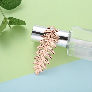 Detailed close-up of a rose gold leaf hair clip with elegant pearl accent and fine texture