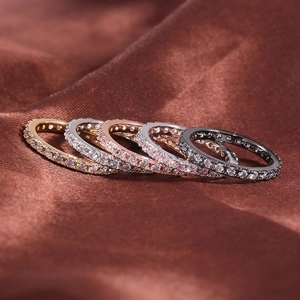Ensemble de cinq bagues éternité avec pierres colorées sur fond de soie brune