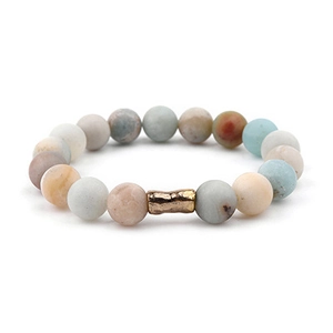 Detail of bohemian natural stone beaded bracelet with textured gold metal cylinder bead