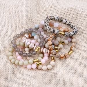 Bohemian natural stone beaded bracelets with golden copper tubes on beige linen background