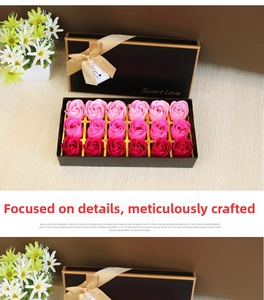 Detail of 18 rose soap flowers in pink and red gradients within a black ribbon gift box