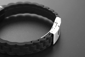 Gros plan sur le bracelet de montre en silicone noir avec boucle déployante en métal argent