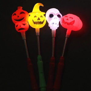 Close-up of glowing LED Halloween pumpkin and skull wands with metal spring necks