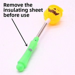 Close-up of Halloween pumpkin glow stick showing the silver spring and insulating pull tab