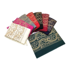 Close-up of multicolored paisley embroidered shawls with elegant gold thread and fringes
