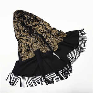 Detail of heavy pashmina shawl featuring golden paisley embroidery and tassel trim