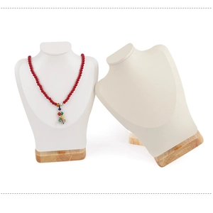 Detail of necklace display stands with solid wood base in white and beige finish