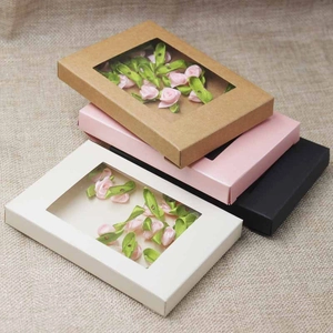 Detail view of rectangular kraft gift boxes with PVC windows in multiple colors on burlap