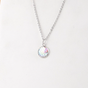 Close-up of a 12mm round iridescent fish scale pendant on a silver steel necklace chain