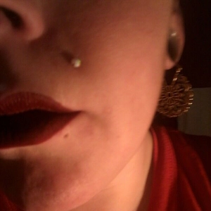 Primer plano de piercing de labio con rosca interna y base plana de acero inoxidable