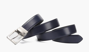 Detail of blue leather belt with rotatable silver buckle on a clean white background