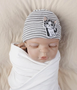 Detail of baby knitted hat with gray stripes and a cute cartoon cat patch embroidery