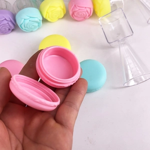 Hand holding macaron shaped plastic cosmetic jar for cream and lip balm storage