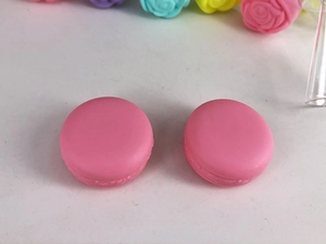 Close-up of pink macaron-shaped plastic storage jars for creams and cosmetics