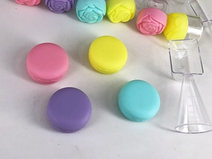Close-up of macaron-style silicone cosmetic jars and 25ml measuring cup tool