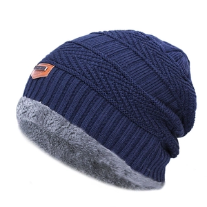 Détail du bonnet en tricot bleu marine avec doublure en fourrure grise et patch