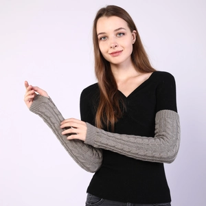 Close-up of dark grey cable knit arm warmers with detailed woven texture on sleeves