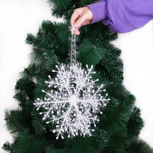 White Christmas snowflake ornament hanging on a festive green tree branch