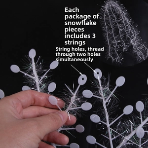 Detail of white glitter snowflakes with hanging holes and silver strings for decoration