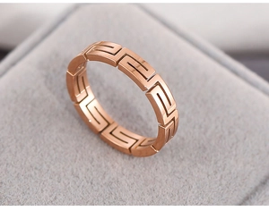 Macro shot of rose gold stainless steel ring with Greca pattern cutout design