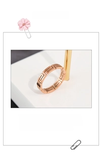 Detail of rose gold titanium steel ring featuring an engraved Greek Key geometric pattern