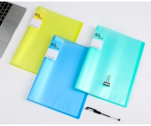 Three translucent A4 display books in yellow, blue, and green on an office desk