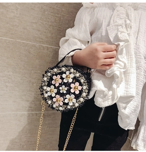 Detailed view of kids round tweed handbag featuring pearl and floral bead decorations