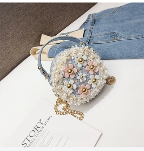 Detail of tweed round kids bag with pearl trim, floral decor and gold chain strap