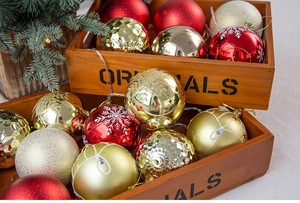 Close-up of 8cm colorful Christmas balls in a vintage wooden box with tree branches