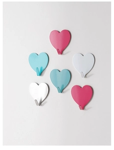 Detail of colorful heart-shaped stainless steel wall hooks with adhesive backing