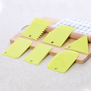 Close-up of 6-piece yellow-green plastic cake scrapers set on a wooden cutting board