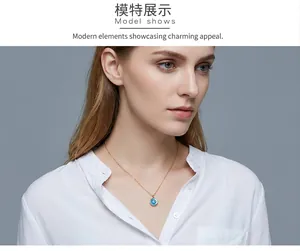 Close-up of golden Evil Eye necklace with blue pendant on a model wearing white shirt