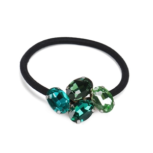 Detailed close-up of green oval crystal rhinestones on a black elastic hair tie band